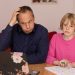 A father and daughter working on a laptop, focusing on home education activities.